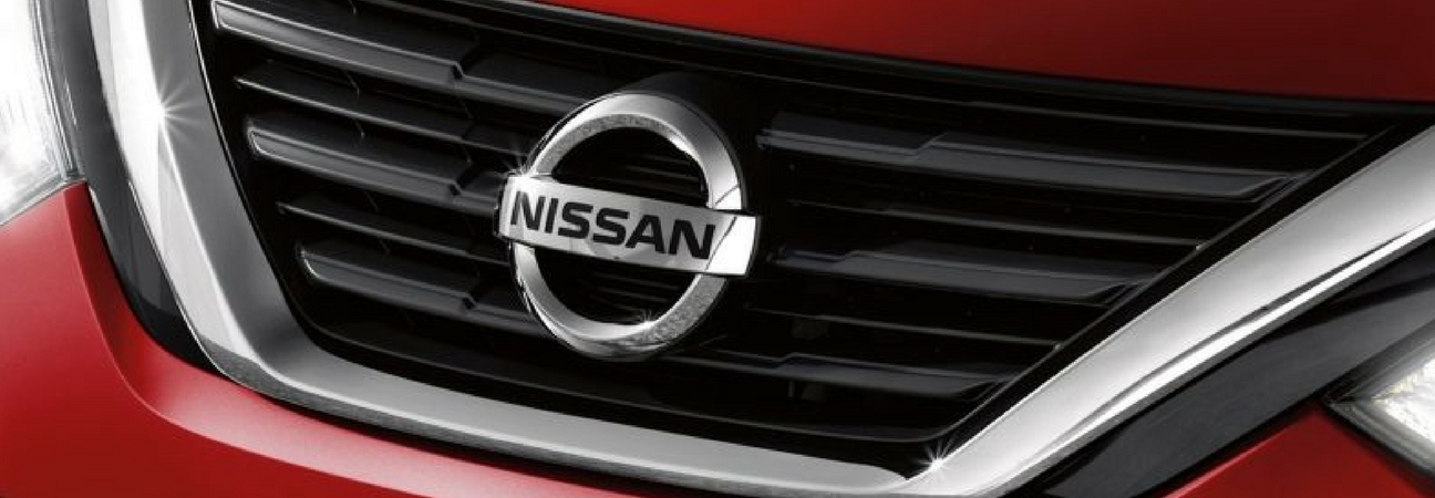 A closeup of a Nissan car's front grille