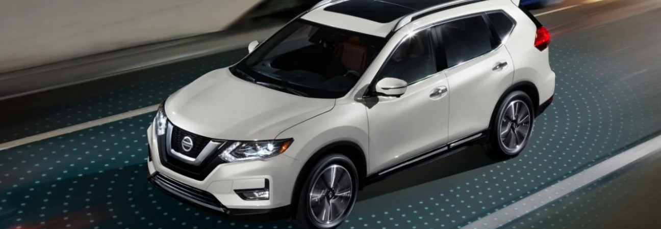 white 2019 Nissan Rogue driving on street