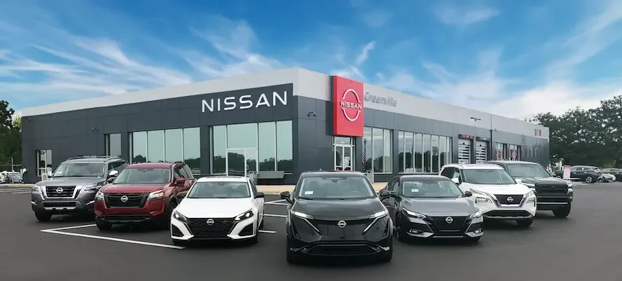 lineup of nissan models in front of dealership